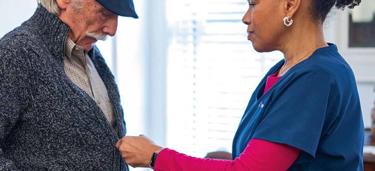 Caregiver assisting a senior client with warmth and compassion